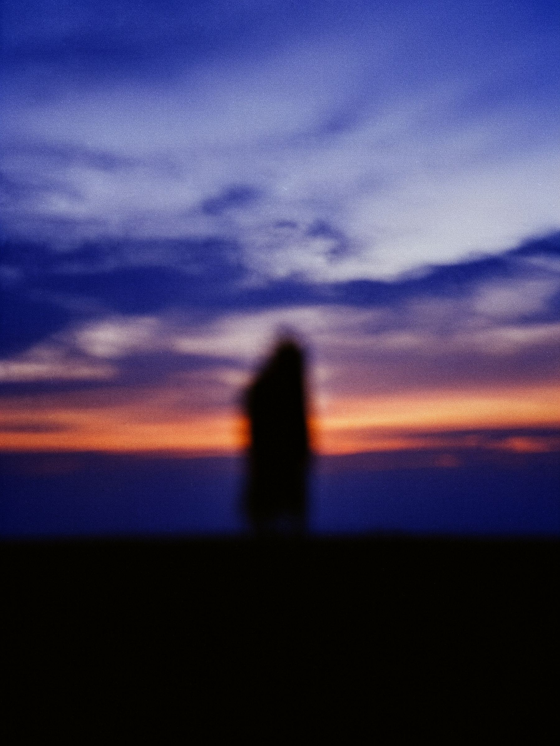 A figure at dusk against an open horizon